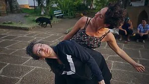 Cata and Carmen, two women dancing outdoors, one supporting the other in a flowing pose.