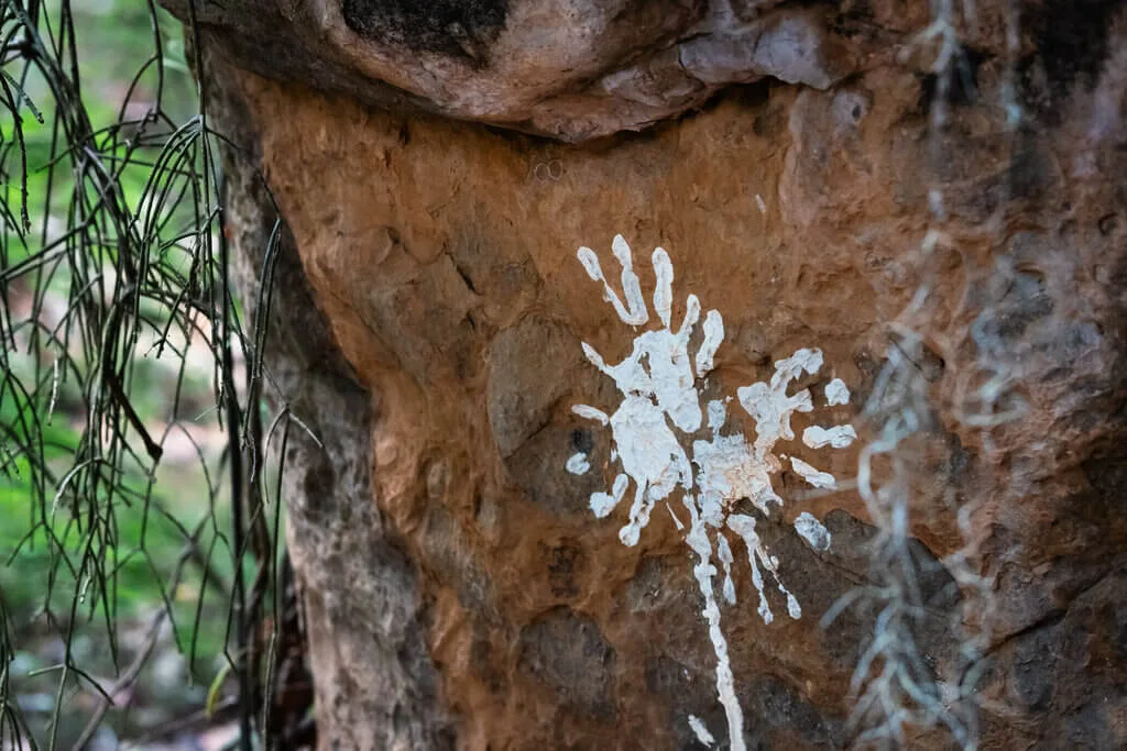 Aboriginal hand stencil art on a rock face, part of the Seed Water Project.