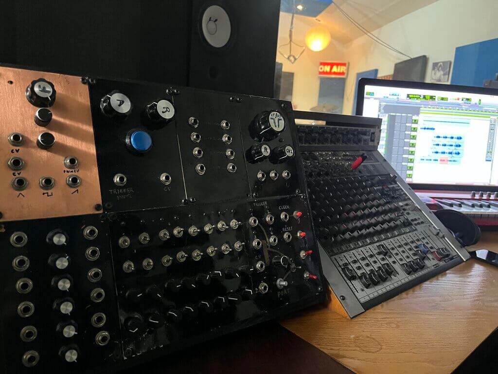 Euforia setup: Modular synthesizer with knobs, mixer, laptop with audio software, and an "On Air" sign.