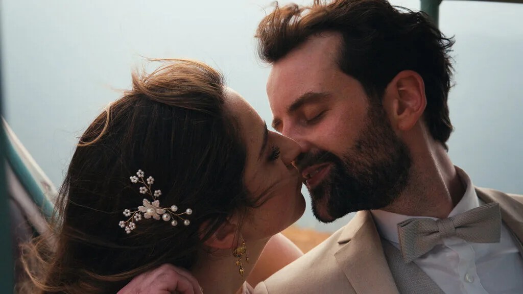 Mariana and Alex share a kiss in a close-up wedding photo.