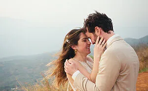 Mariana and Alex embracing on their wedding day with a scenic mountain backdrop.