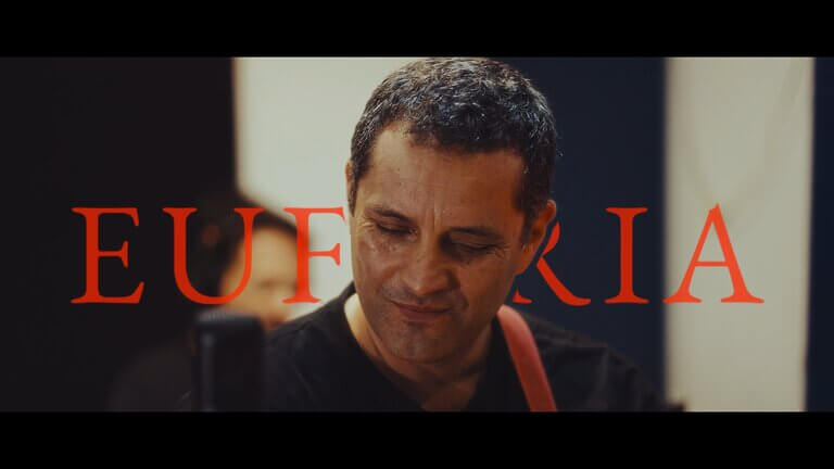 Close-up of a musician performing with "Euforia" text overlay.