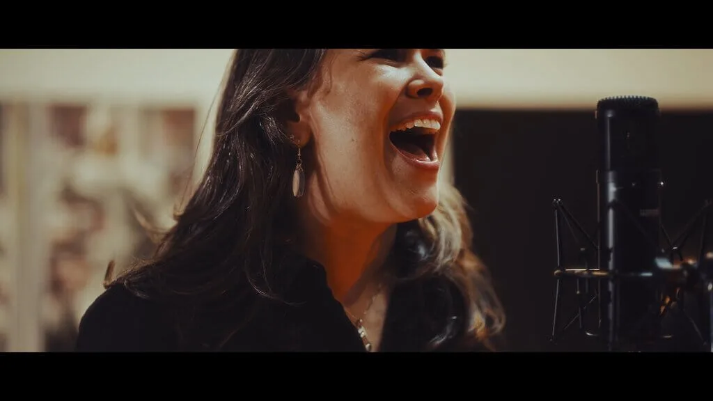 Singer with microphone performing with euforia in a recording studio