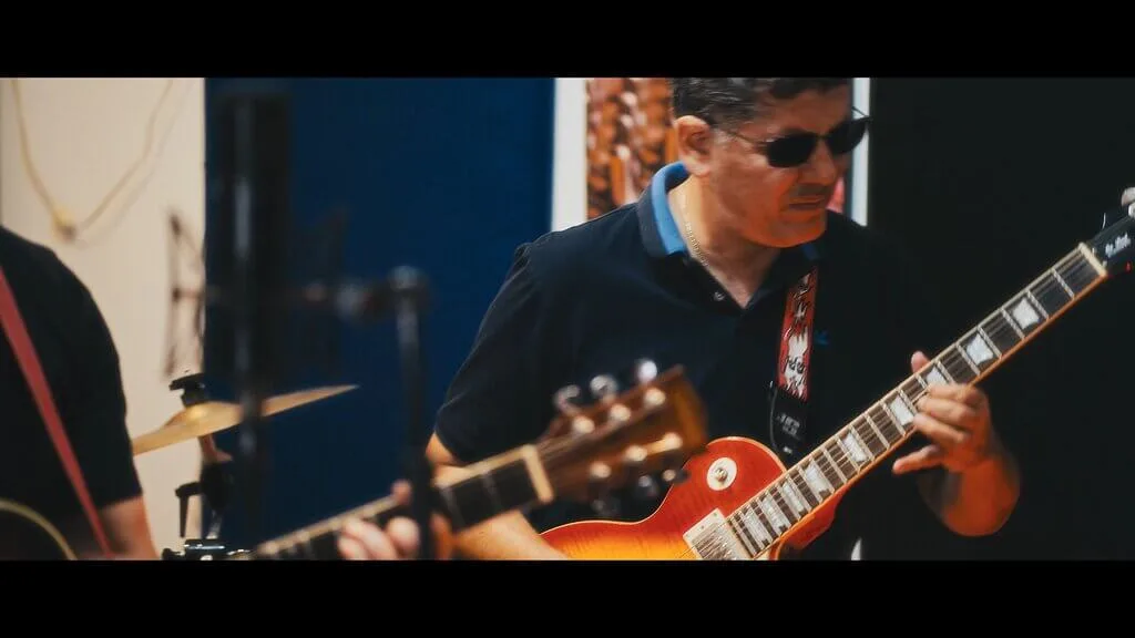 Musician playing electric guitar with band. "Euforia" in action.