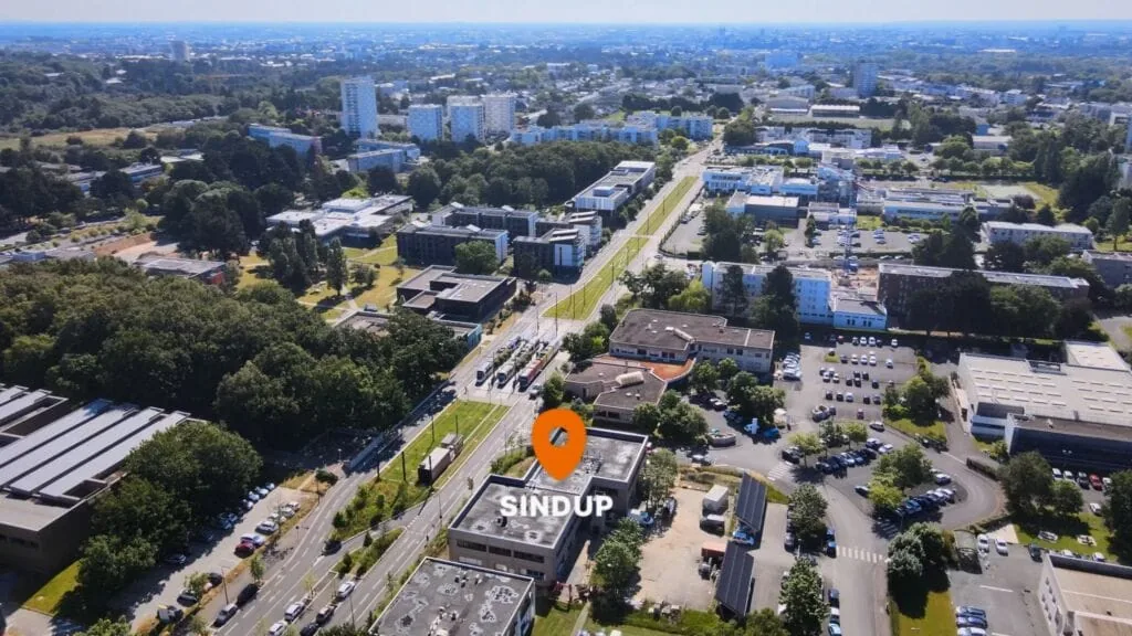 Aerial view of Sindup building with surrounding cityscape and green spaces.