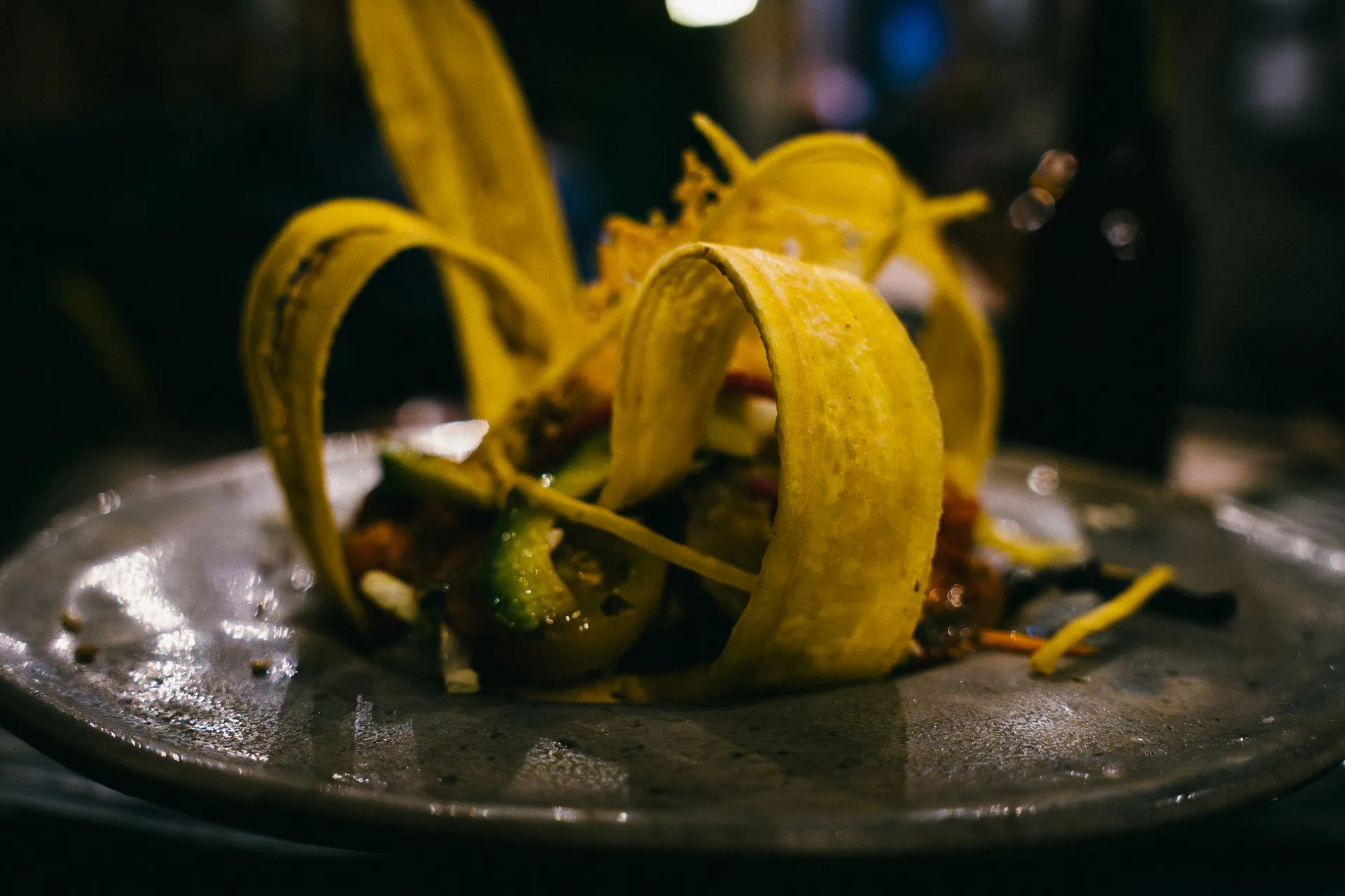 Plantain taco with avocado and salsa on a gray plate.